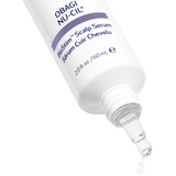 A close-up of a white Obagi Nu-Cil BioStim Scalp Serum bottle with a clear dropper tip dispensing serum, shown on a white background.